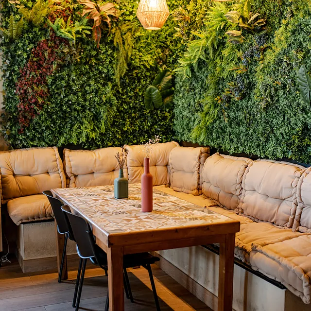 Neroli Cocktail Restaurant sofa de esquina con enredadera y mesa